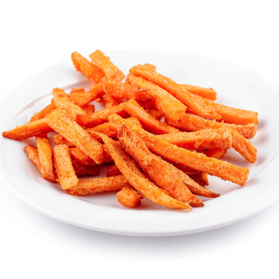 A white plate piled high with crispy, golden-orange sweet potato fries from Wolfy's Leesburg Restaurant.